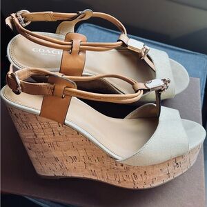 Coach women’s sandal. Neutral leather strap, gold metal accents, cork heel.